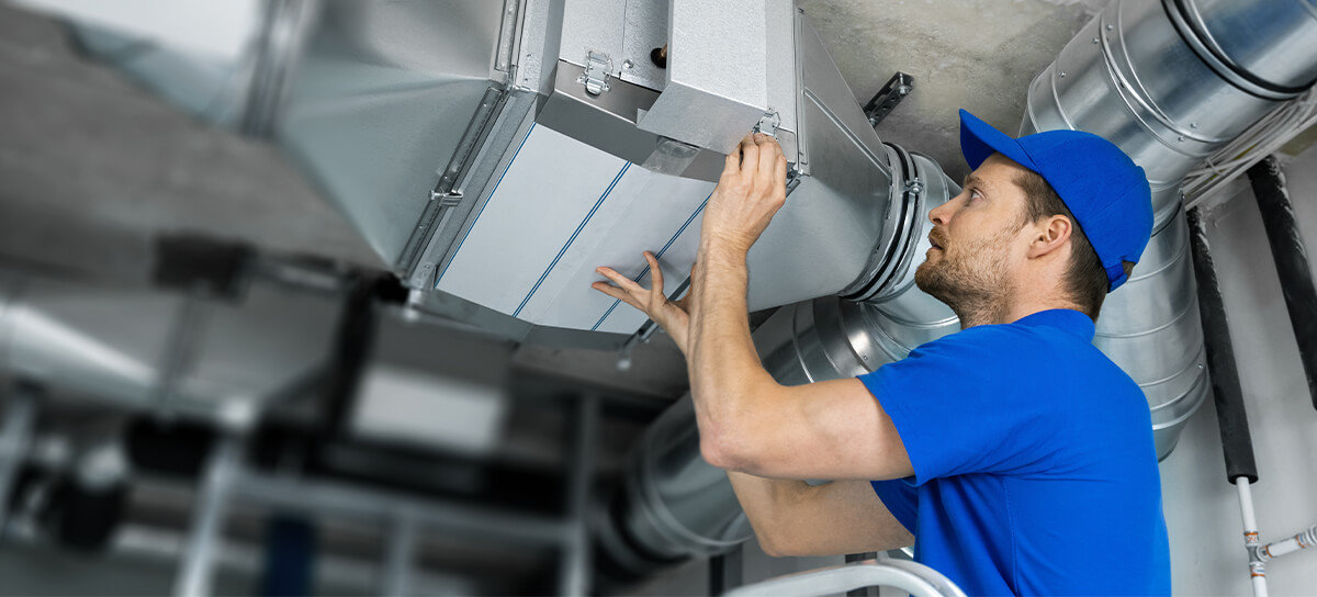 HVAC technician working on duct work.